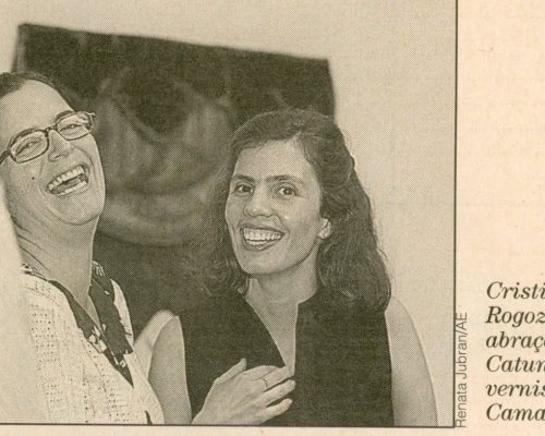 Foto de Cristina Rogozinski com Leda Catunda na Galeria Camargo Vilaça, Coluna Persona de Cesar Giobbi, O Estado de São Paulo, São Paulo, SP, 4 set.1998, Caderno 2, D5